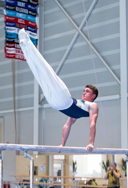 Male gymnast performs impressive L-position strength hold on horizontal bar during training session